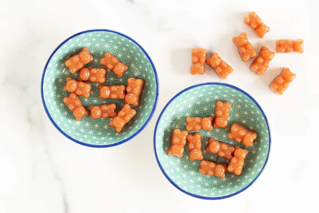 Homemade strawberry and carrot gummy bears served in blue bowls